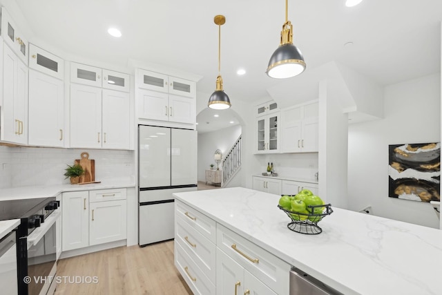 kitchen with white refrigerator, pendant lighting, black / electric stove, and white cabinets