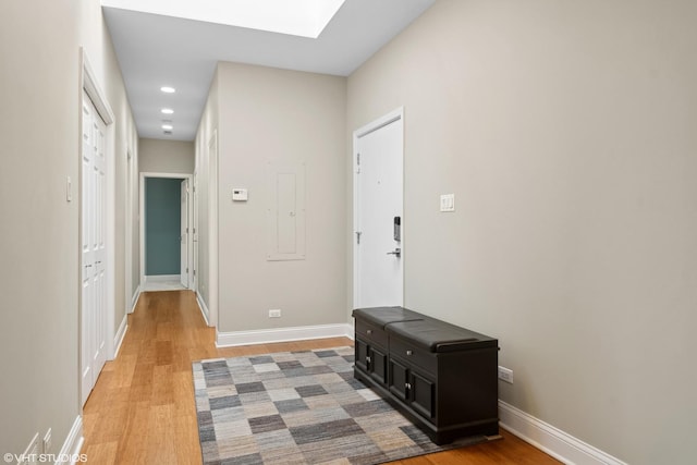 hall with hardwood / wood-style flooring and a skylight