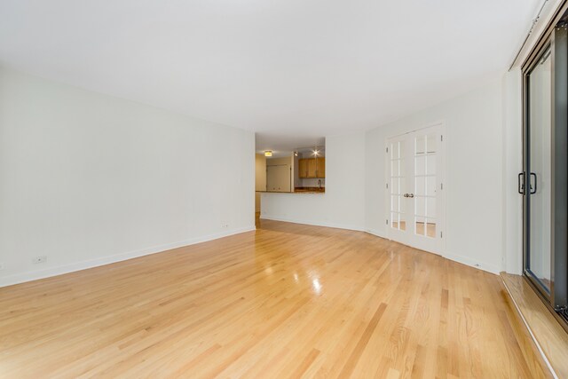 empty room with french doors and light hardwood / wood-style floors