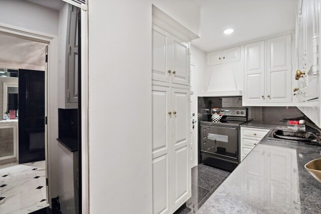 kitchen with sink, backsplash, white cabinetry, electric range, and custom range hood