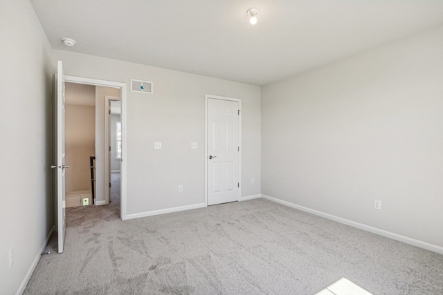 unfurnished bedroom with light carpet and a closet