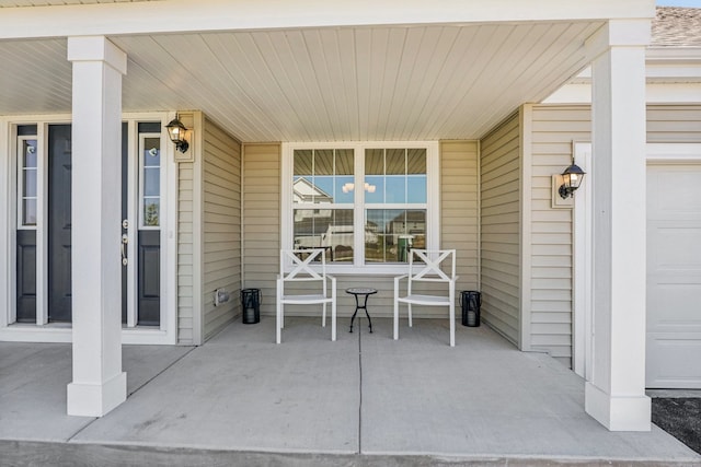 view of patio / terrace with a porch and a garage