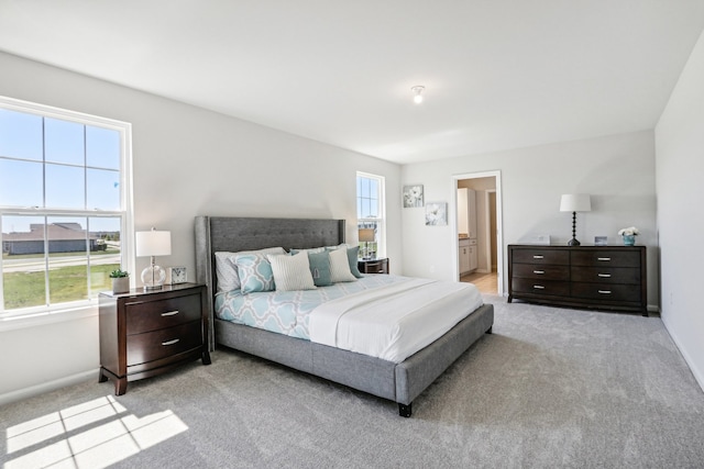 carpeted bedroom featuring ensuite bathroom