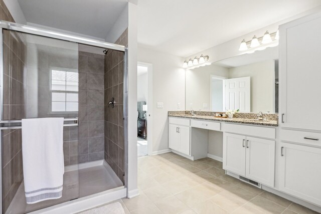 bathroom with a shower with shower door, tile patterned flooring, and vanity