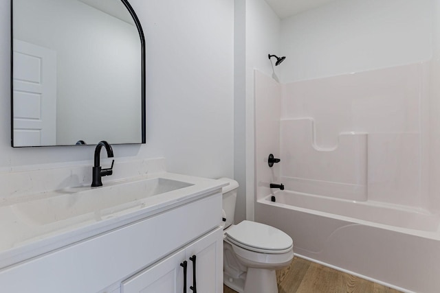 full bathroom featuring vanity, wood-type flooring,  shower combination, and toilet