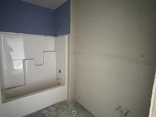 bathroom with a washtub and concrete flooring