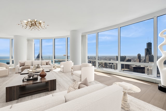 living room with a healthy amount of sunlight, an inviting chandelier, hardwood / wood-style floors, and floor to ceiling windows