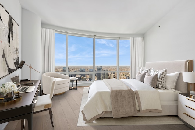 bedroom featuring floor to ceiling windows and hardwood / wood-style floors