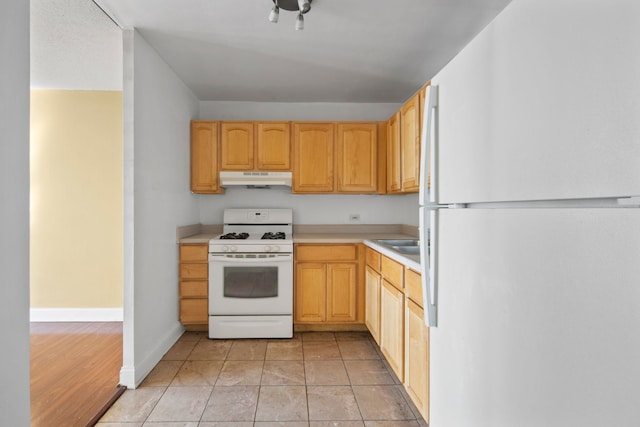 kitchen featuring white appliances, light hardwood / wood-style flooring, and light brown cabinets