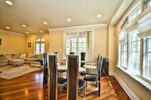 dining room with dark hardwood / wood-style flooring and crown molding