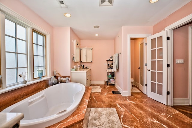 bathroom with vanity, hardwood / wood-style flooring, toilet, and a bathing tub