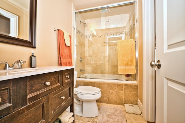 full bathroom featuring tile patterned floors, vanity, toilet, and bath / shower combo with glass door