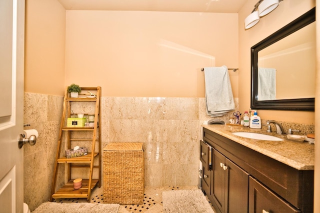 bathroom featuring tile patterned flooring, vanity, and tile walls