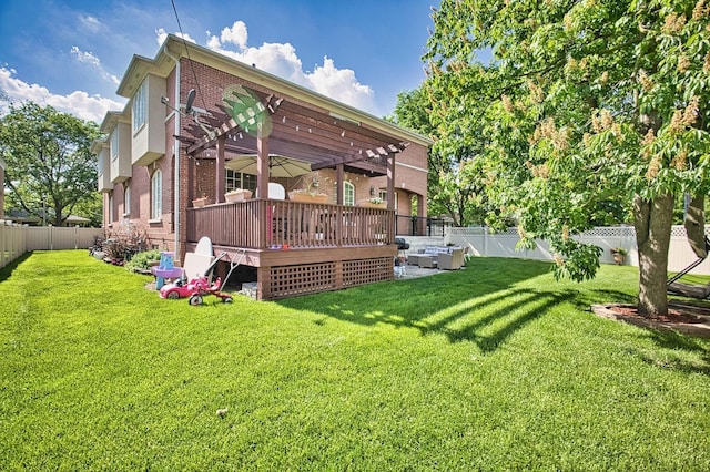 rear view of house with a yard, a pergola, and a wooden deck