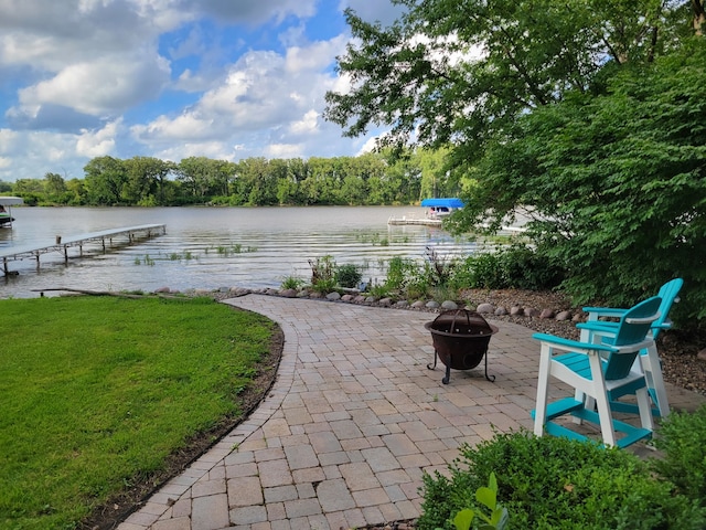 view of patio / terrace featuring a dock, a water view, and an outdoor fire pit