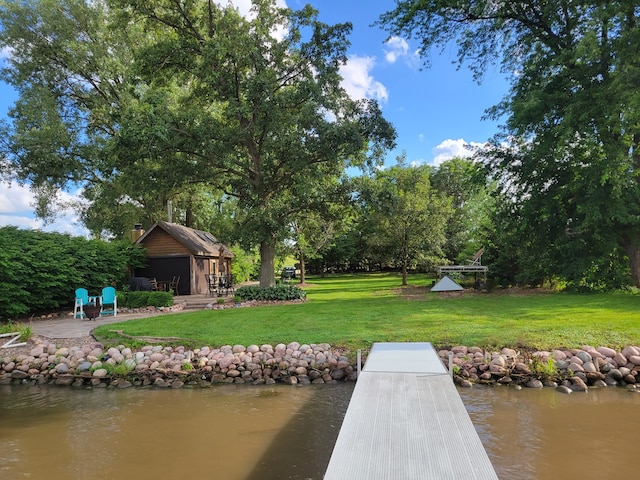 dock area with a water view and a lawn