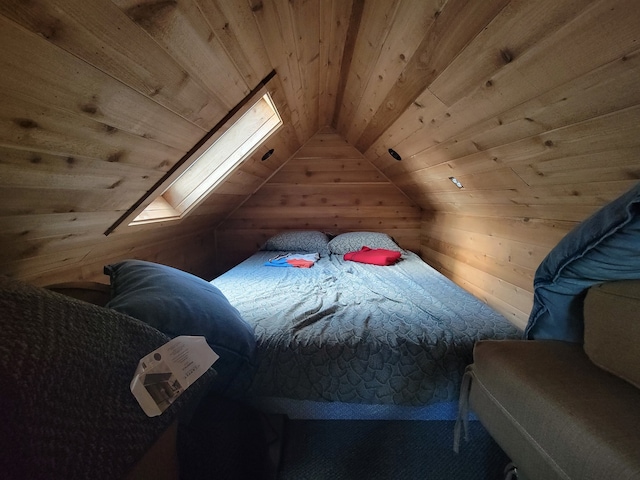 bedroom with vaulted ceiling with skylight and wooden ceiling