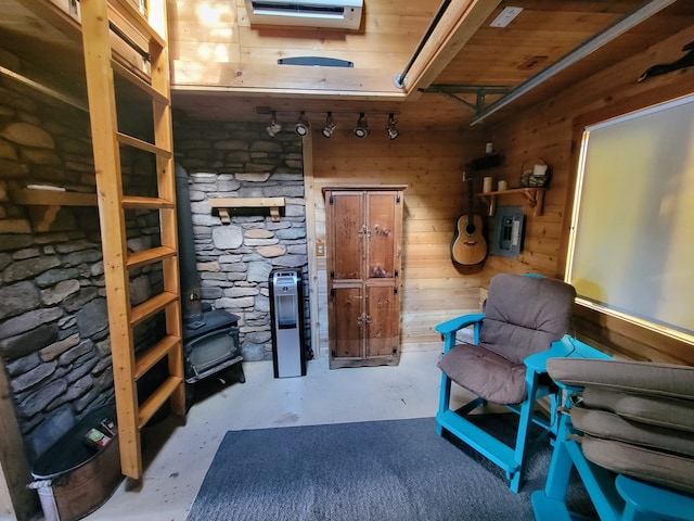 sitting room featuring wooden ceiling, concrete floors, and wooden walls