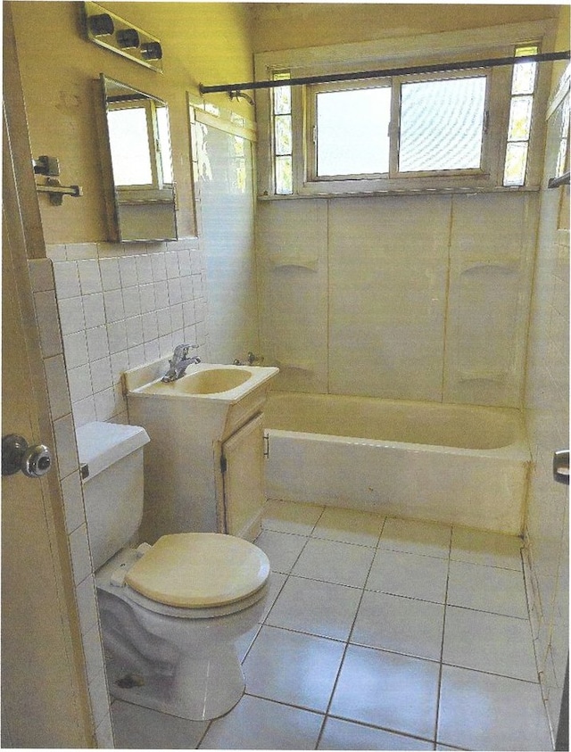 full bathroom featuring vanity, tile walls, plenty of natural light, and toilet