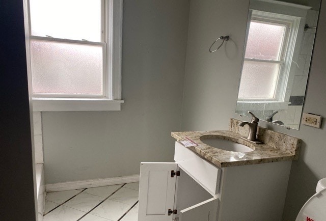 bathroom featuring plenty of natural light, vanity, and tile floors