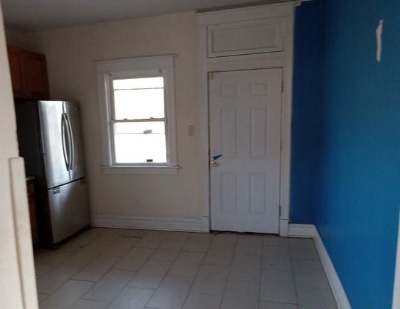 kitchen with light tile floors and stainless steel fridge