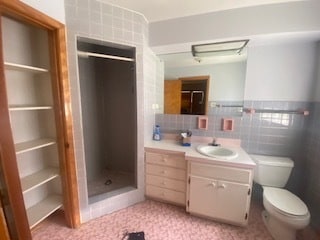 bathroom featuring tile walls, oversized vanity, tile flooring, tasteful backsplash, and toilet