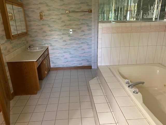 bathroom featuring tiled tub, vanity, and tile patterned floors