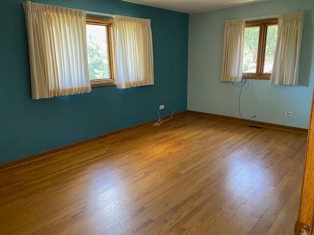 unfurnished room with wood-type flooring