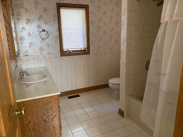 full bathroom with tile patterned flooring, shower / bathtub combination with curtain, toilet, and vanity