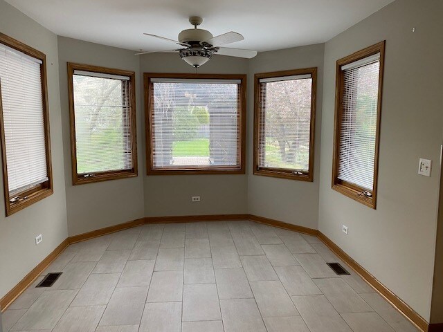 empty room with light tile patterned floors and ceiling fan