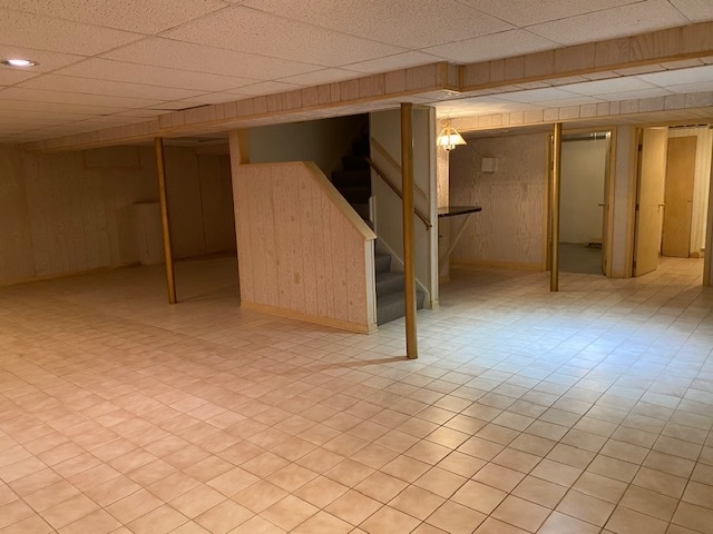 basement with light tile patterned flooring and a drop ceiling