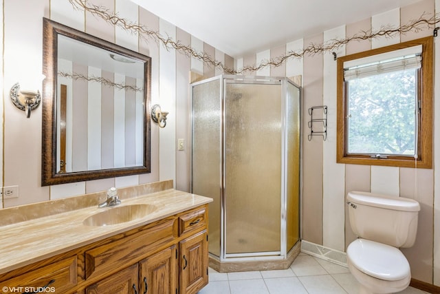 bathroom with a shower with door, vanity, tile patterned flooring, and toilet