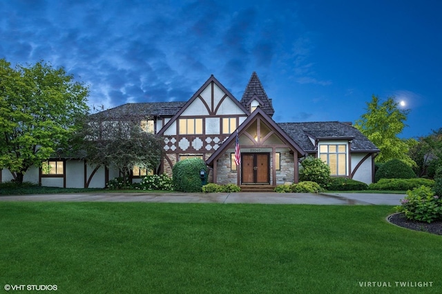 english style home featuring a yard