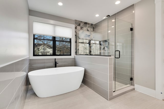 bathroom with tile flooring, tile walls, and plus walk in shower