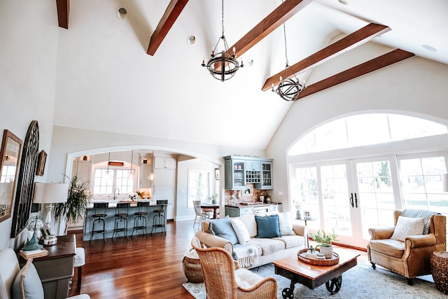 living room with high vaulted ceiling, wood-type flooring, beamed ceiling, and a chandelier