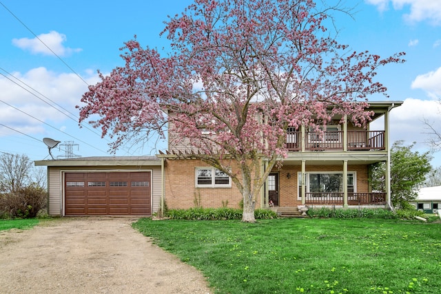 view of front of home featuring a front lawn, a porch, a balcony, and a garage