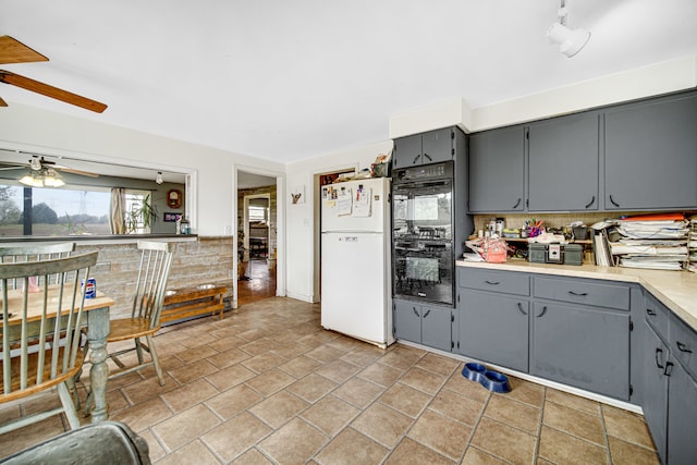 kitchen with white fridge, backsplash, double oven, ceiling fan, and light tile floors