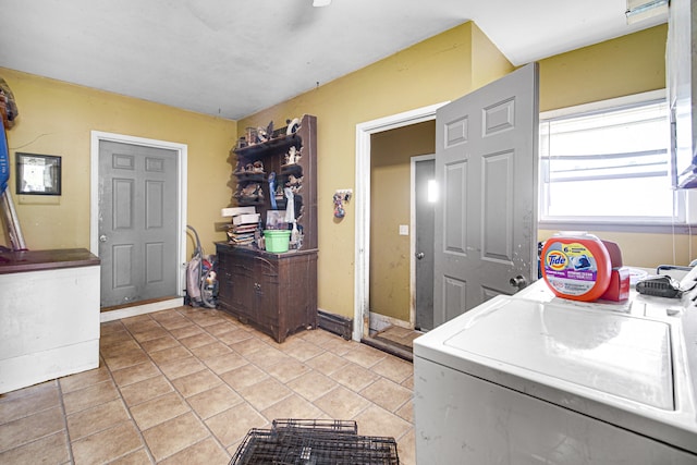 laundry room featuring light tile floors and washing machine and clothes dryer