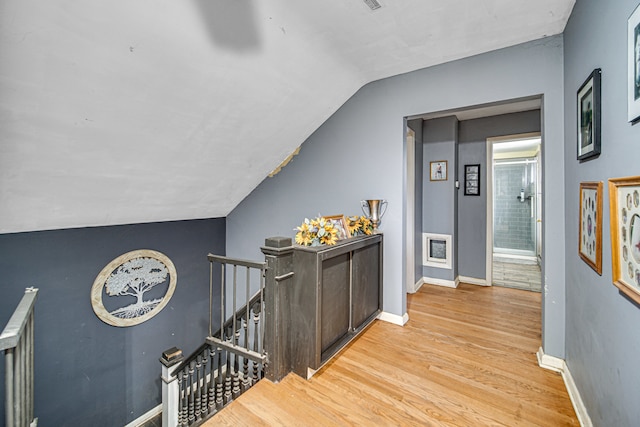 hall featuring vaulted ceiling and light wood-type flooring