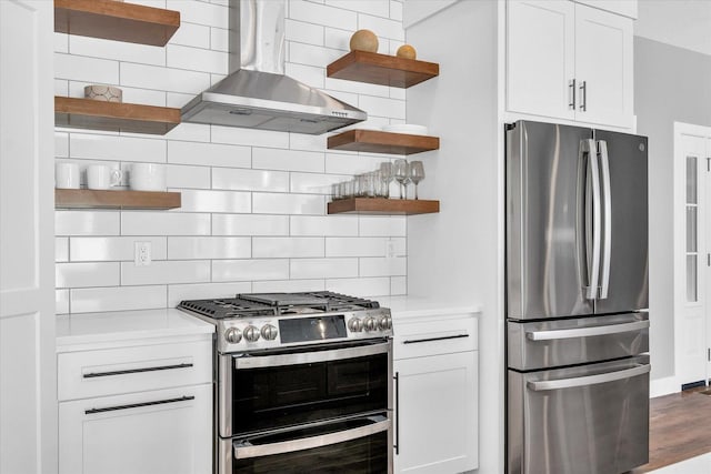 kitchen with tasteful backsplash, stainless steel appliances, white cabinetry, and wall chimney exhaust hood