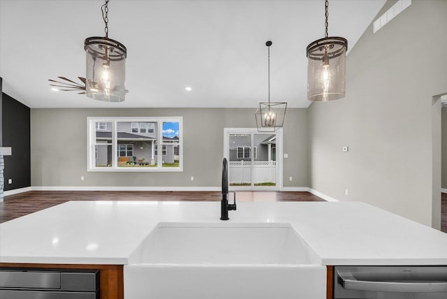 kitchen featuring stainless steel dishwasher, a kitchen island with sink, pendant lighting, and sink