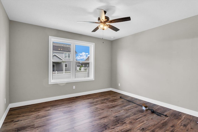 spare room featuring dark hardwood / wood-style flooring and ceiling fan