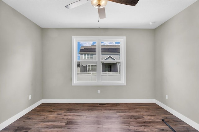 unfurnished room featuring dark wood-type flooring and ceiling fan