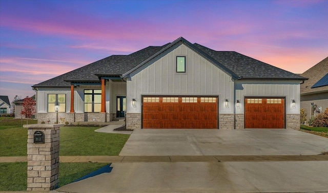 view of front of property with a garage and a lawn