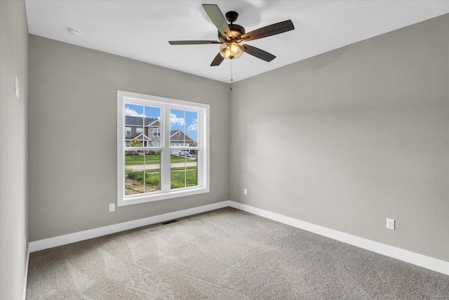 empty room featuring ceiling fan and carpet