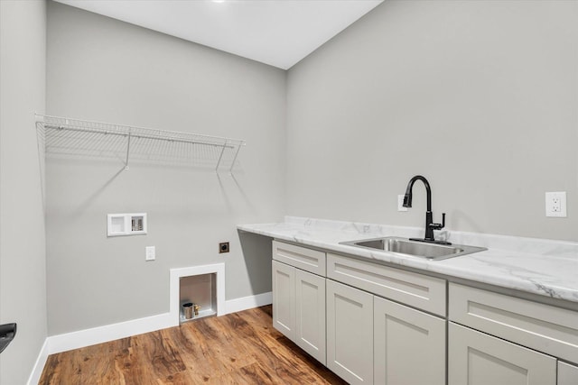 laundry room featuring sink, electric dryer hookup, light wood-type flooring, cabinets, and washer hookup