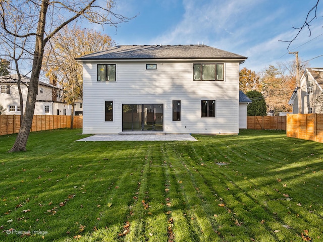 back of house with a yard and a patio