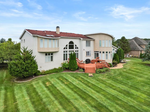 rear view of house featuring a deck and a yard