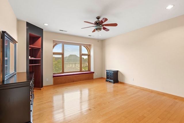 spare room with ceiling fan and light wood-type flooring