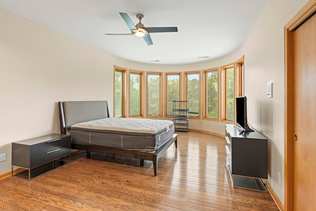 bedroom with light hardwood / wood-style floors and ceiling fan